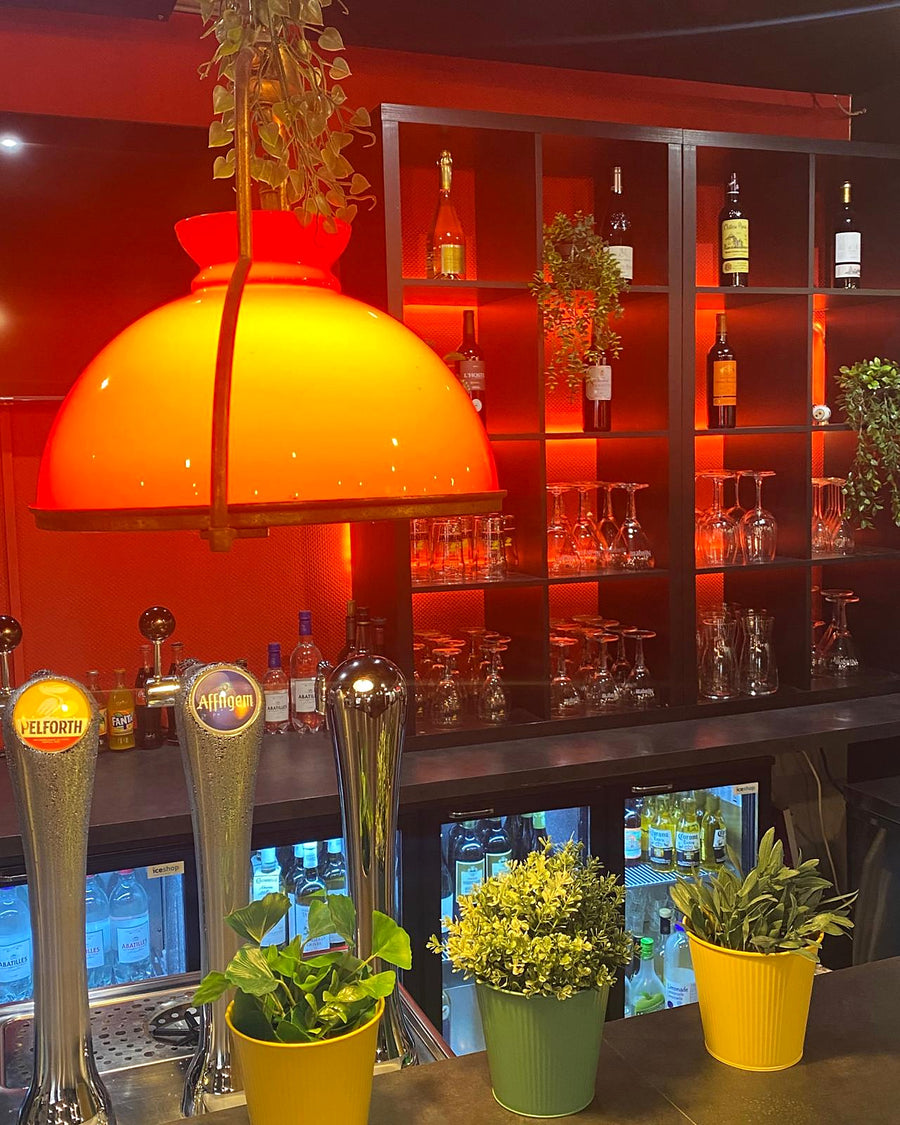 Le comptoir du 15 Lounge, étagères de bouteilles et lumière orangée